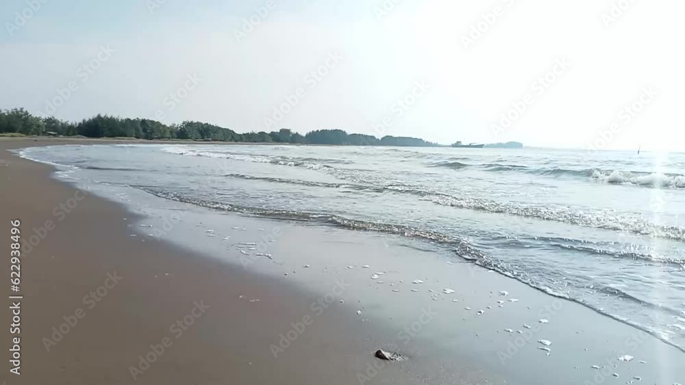 Waves crashing on the beach, flowing over grains of sand Waves crashing on the beach, flowing over grains of sand