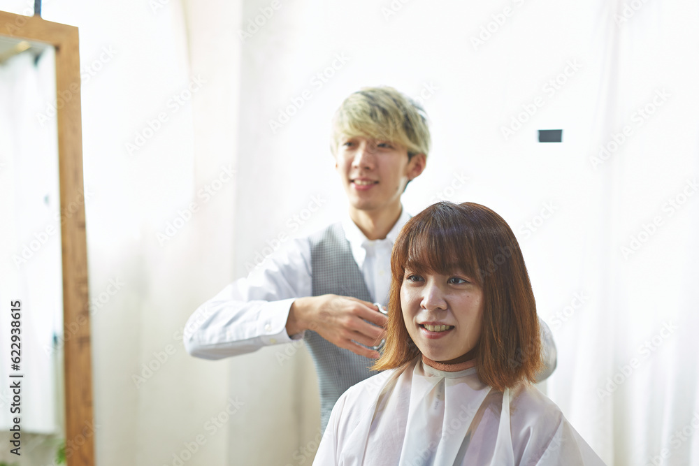 客と会話しながら髪を切る美容師 客と会話しながら髪を切る美容師