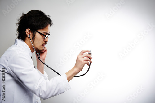 聴診器を当てる男性医師の横顔 photo