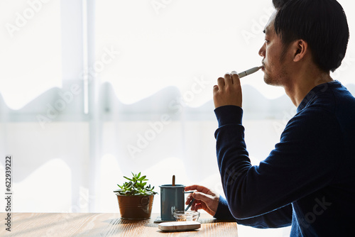 カフェでアイコスを吸う男性 photo