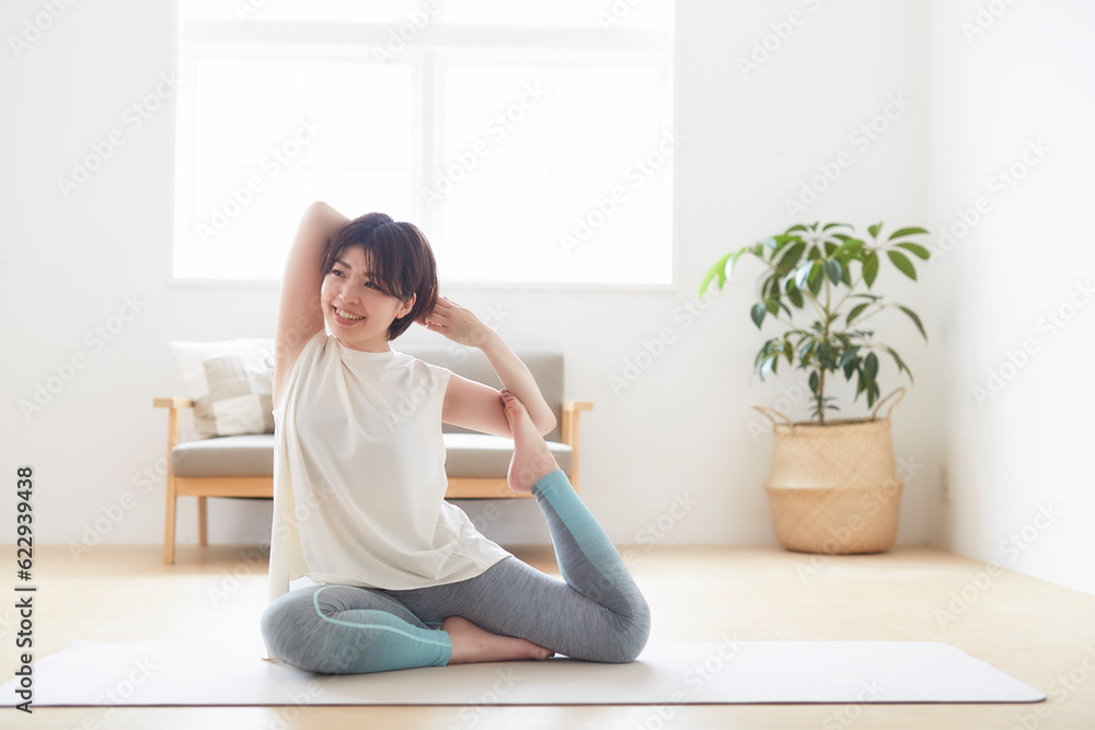 室内の床でヨガのポーズをとる女性 室内の床でヨガのポーズをとる女性
