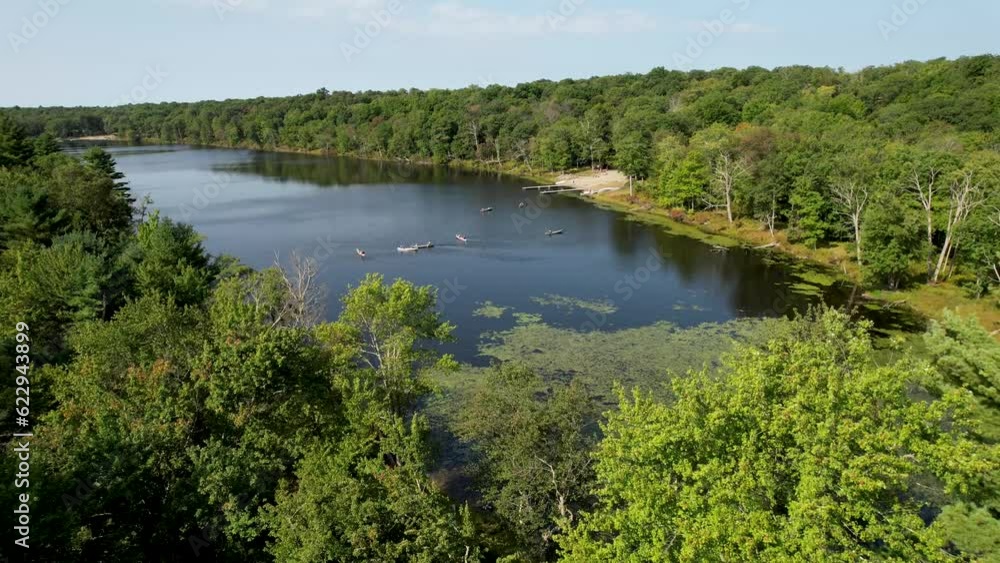 Drone flyover summer trees to pond with canoes shot in pocono mountains
Drone flyover summer trees to pond with canoes shot in pocono mountains