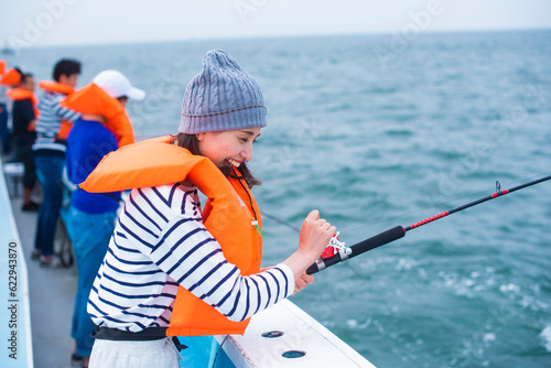 船で海釣りする20代男女3人 photo