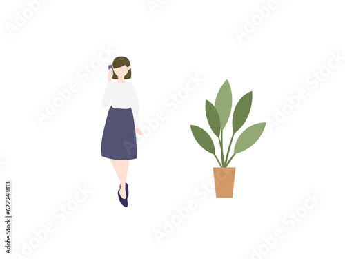 スマホで通話する女性と観葉植物