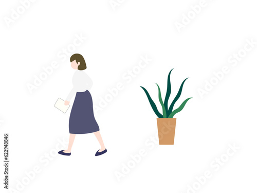 書類を持って歩く女性と観葉植物