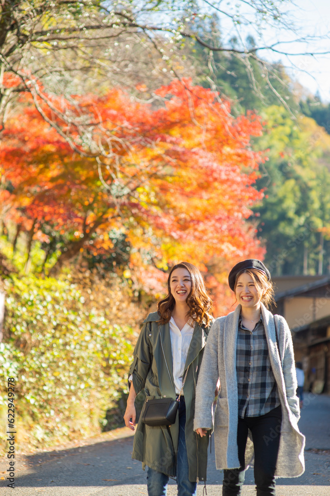 紅葉を見ながら観光地を散策する女性２人