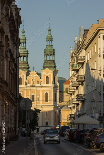 Poznan, Poland - June 12, 2023: view of Dluga street with St. Francis Seraphim church during sunset, golden hour. © Kseniia