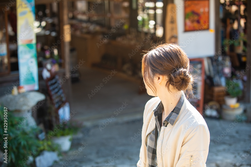 観光地のお店を振り返る女性 観光地のお店を振り返る女性