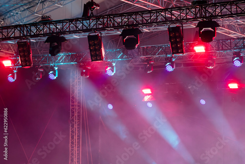 colorful lights of projectors on outdoor concert stage. stage lightning equipment.