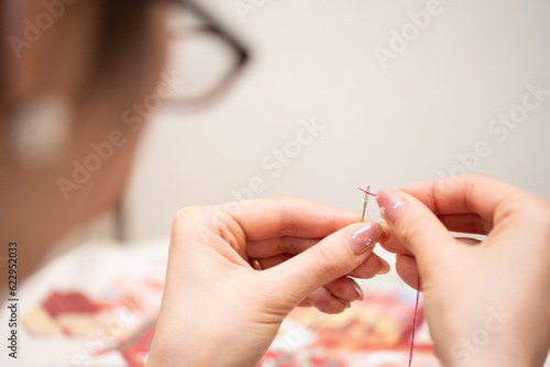 針に糸を通す女性 photo