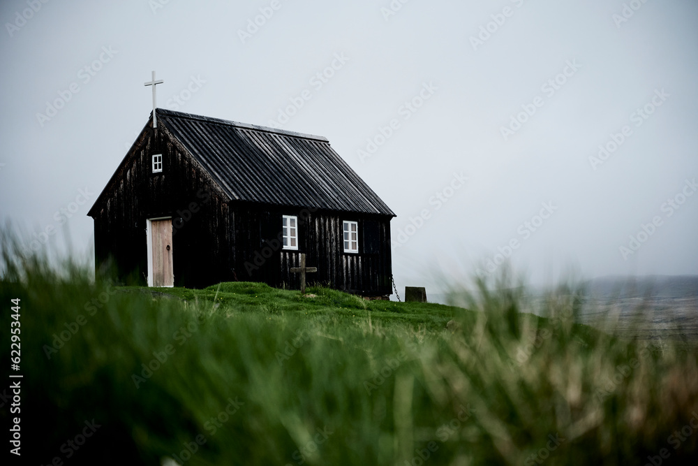 Old black church on green meadow Old black church on green meadow