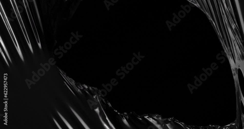 Immerse yourself in tactile wonderland where stretched plastic film converges with velvety black void creating symphony of textures that mirrors delicate intriguing nature of rumpled cellophane wrap.