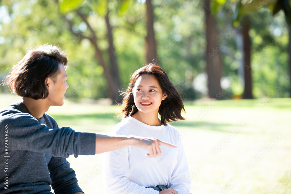 芝生に座って話をしている男女二人 芝生に座って話をしている男女二人