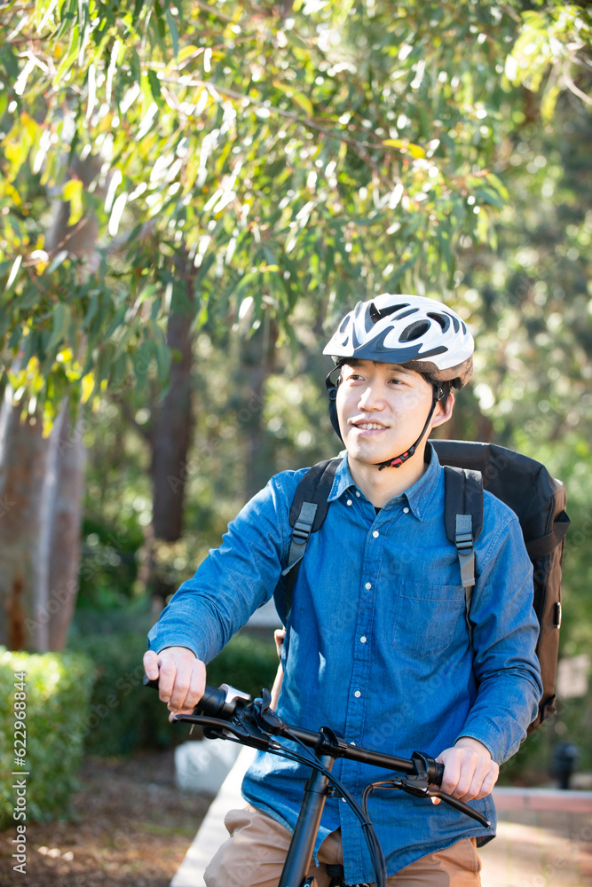 自転車に乗っているるフードデリバリー配達員男性 自転車に乗っているるフードデリバリー配達員男性