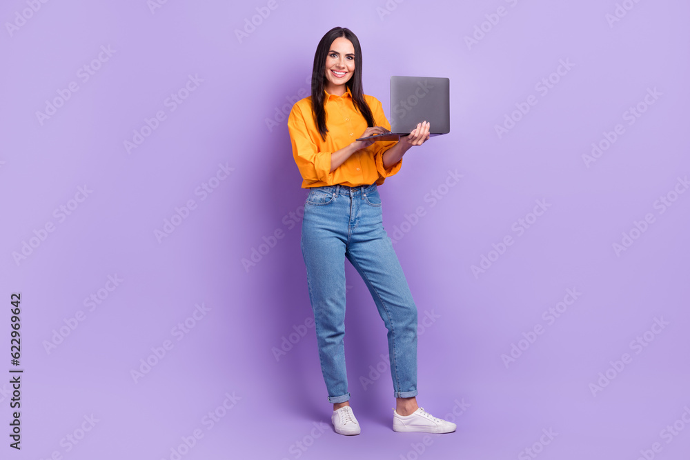Full size photo of positive adorable smart woman dressed oversize shirt hold laptop read email isolated on violet color background Full size photo of positive adorable smart woman dressed oversize shirt hold laptop read email isolated on violet color background