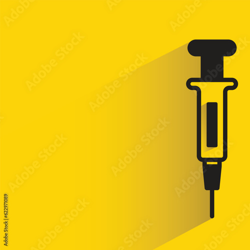 medical syringe with shadow on yellow background