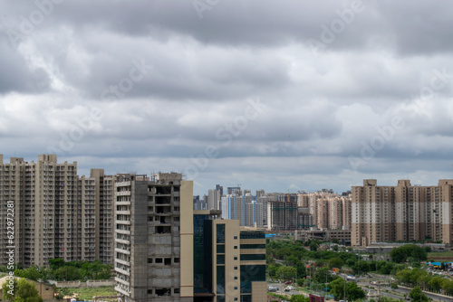 Dense clouds rolling over metro city. High rise apartments seen with dense clouds in the background. Beautiful rainy weather view from balcony of a residential building in india.