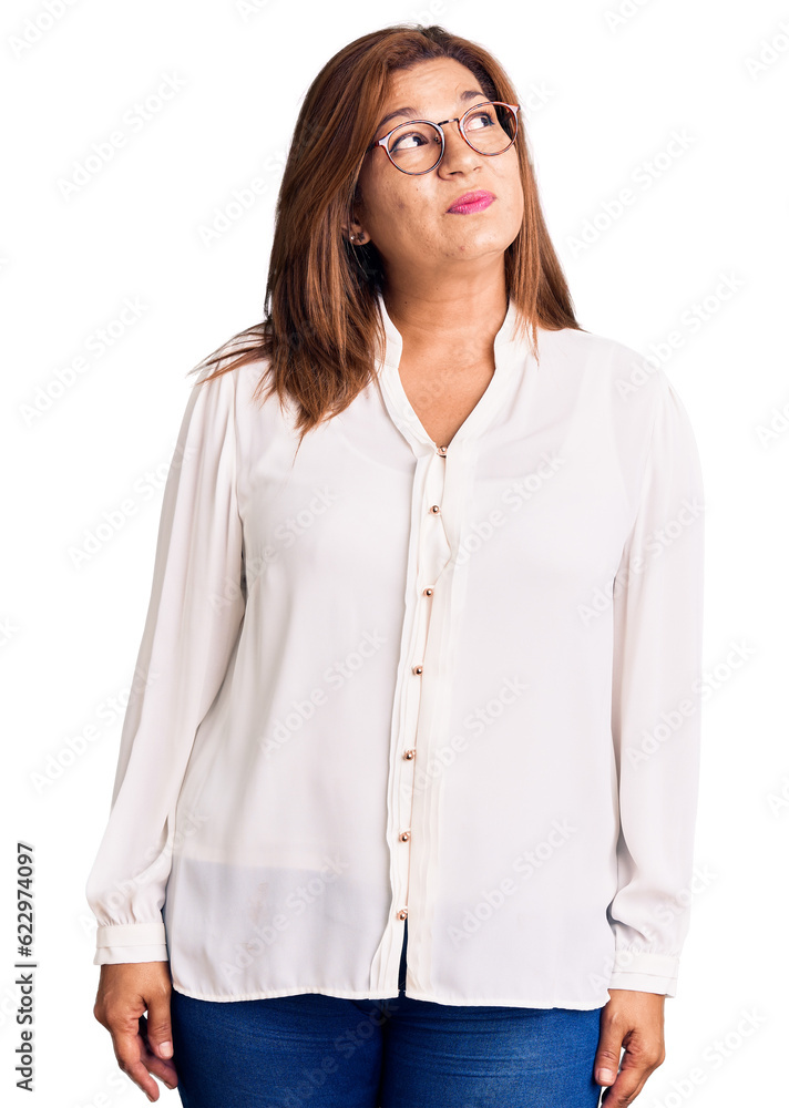 Middle age latin woman wearing casual clothes and glasses smiling looking to the side and staring away thinking. Middle age latin woman wearing casual clothes and glasses smiling looking to the side and staring away thinking.