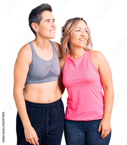 Couple of women wearing sportswear looking away to side with smile on face, natural expression. laughing confident. © Krakenimages.com