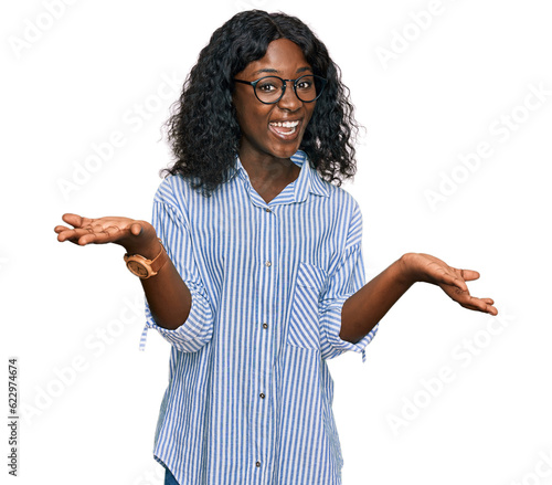 Beautiful african young woman wearing casual clothes and glasses smiling cheerful with open arms as friendly welcome, positive and confident greetings