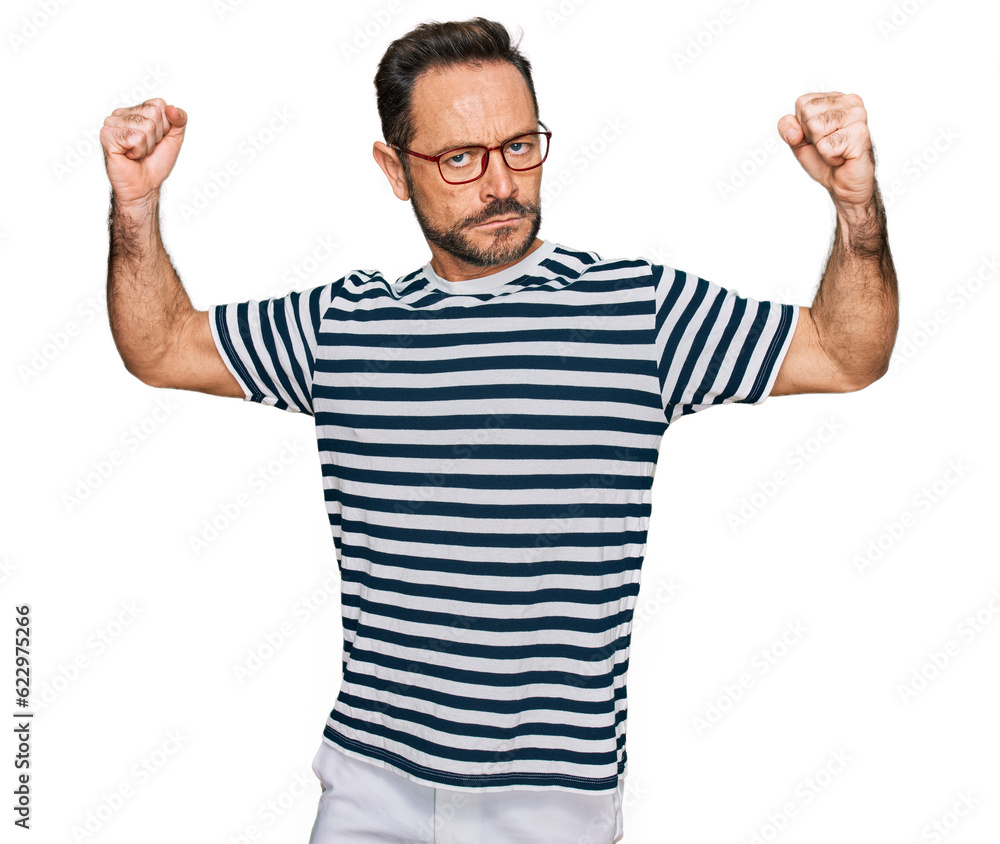Middle age man wearing casual clothes and glasses showing arms muscles smiling proud. fitness concept. Middle age man wearing casual clothes and glasses showing arms muscles smiling proud. fitness concept.