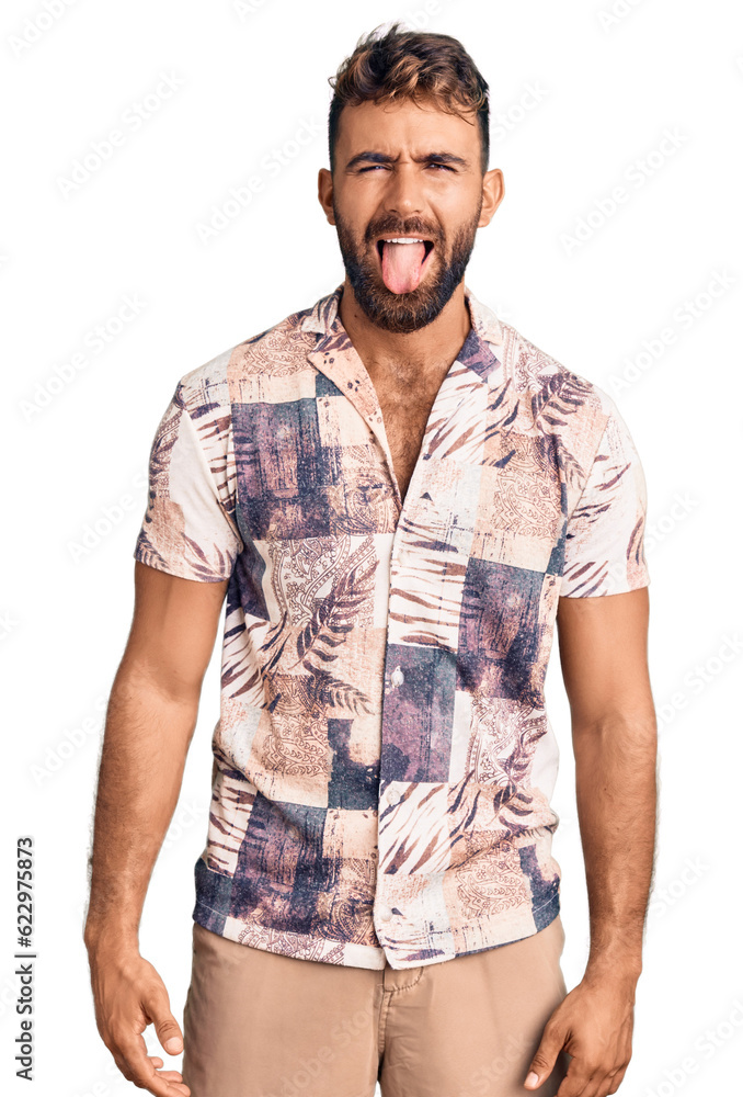 Fototapeta premium Young hispanic man wearing summer clothes sticking tongue out happy with funny expression. emotion concept.