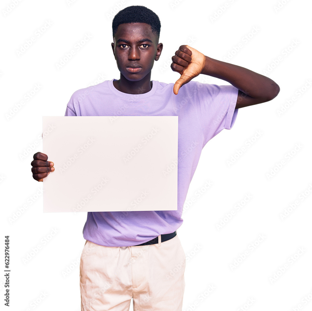 Young african american man holding blank empty banner with angry face, negative sign showing dislike with thumbs down, rejection concept Young african american man holding blank empty banner with angry face, negative sign showing dislike with thumbs down, rejection concept