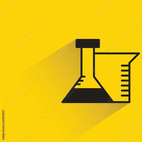 lab flask with shadow on yellow background