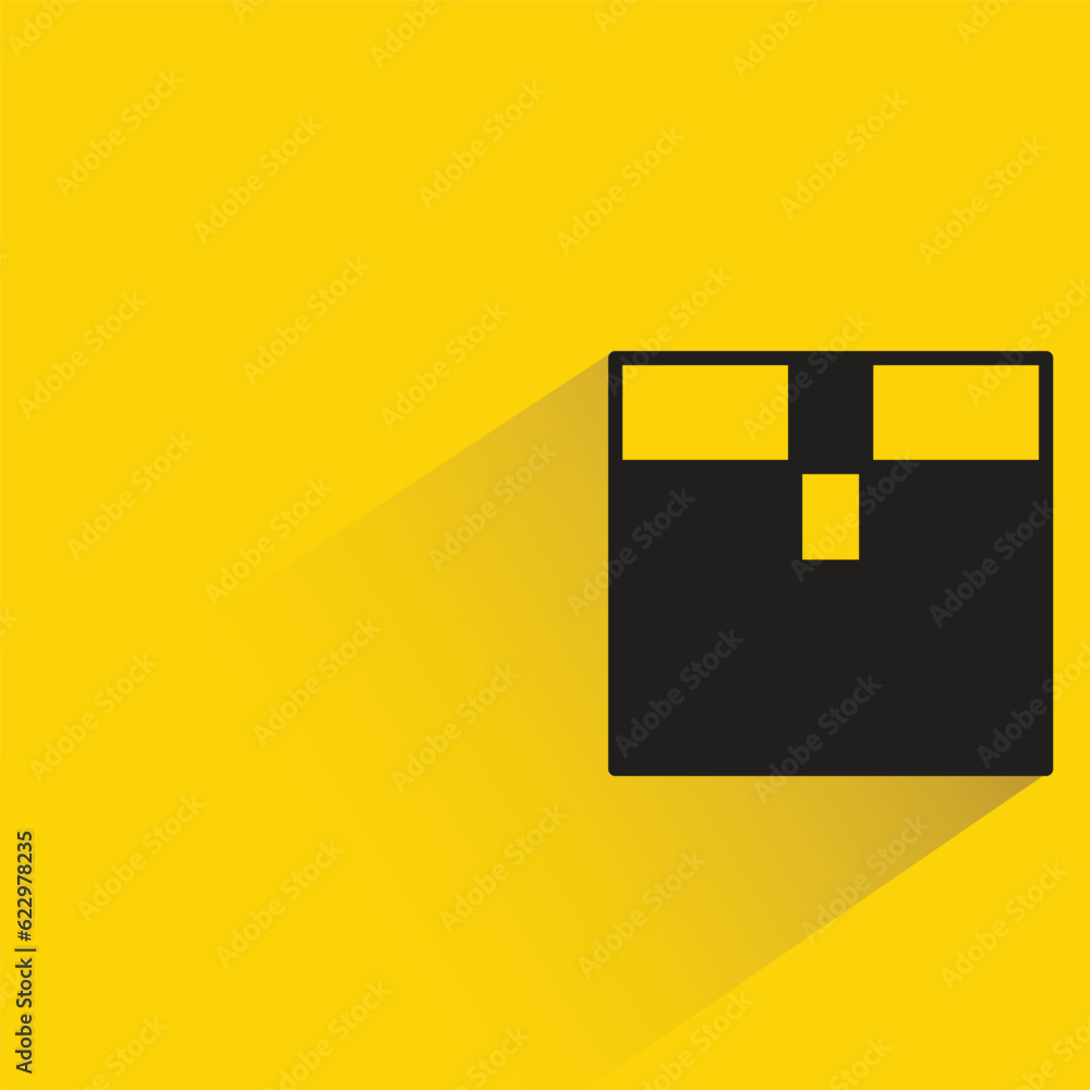 cardboard box with shadow on yellow background cardboard box with shadow on yellow background