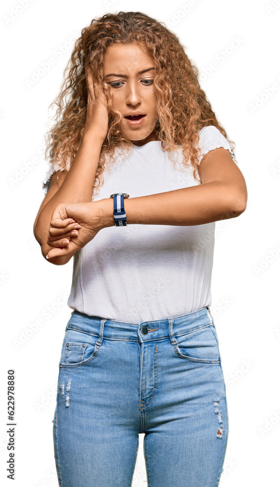 Beautiful caucasian teenager girl wearing casual white tshirt looking at the watch time worried, afraid of getting late Beautiful caucasian teenager girl wearing casual white tshirt looking at the watch time worried, afraid of getting late