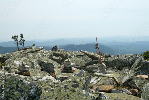Panorama, landscape. In the foreground are rocks covered with moss, in the background are mountains. Summer, blue sky, day.