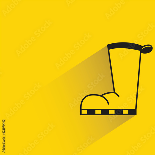 rubber boot with shadow on yellow background