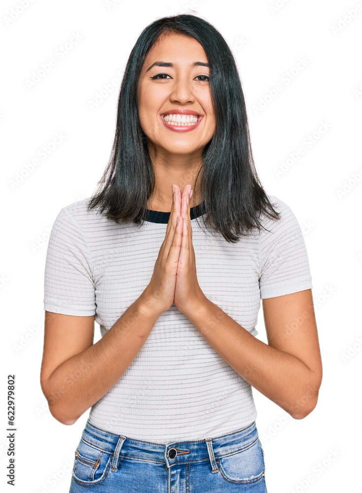 Beautiful asian young woman wearing casual white t shirt praying with hands together asking for forgiveness smiling confident. Beautiful asian young woman wearing casual white t shirt praying with hands together asking for forgiveness smiling confident.
