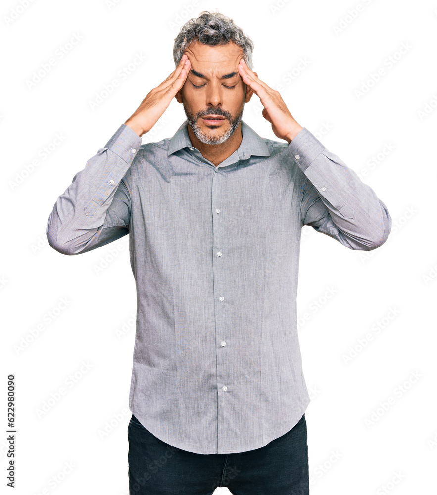 Middle age grey-haired man wearing casual clothes with hand on head for pain in head because stress. suffering migraine. Middle age grey-haired man wearing casual clothes with hand on head for pain in head because stress. suffering migraine.