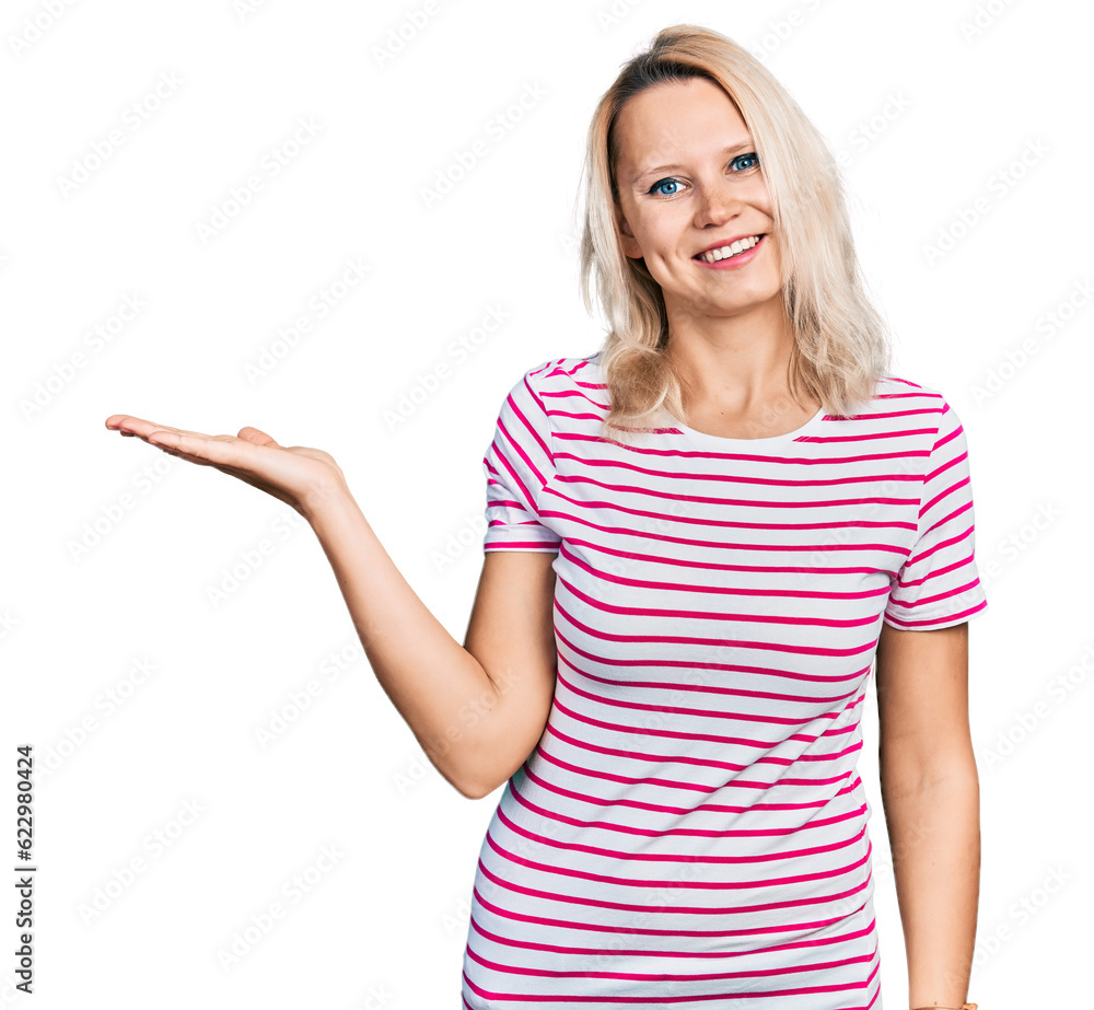 Young caucasian woman wearing casual clothes smiling cheerful presenting and pointing with palm of hand looking at the camera. Young caucasian woman wearing casual clothes smiling cheerful presenting and pointing with palm of hand looking at the camera.