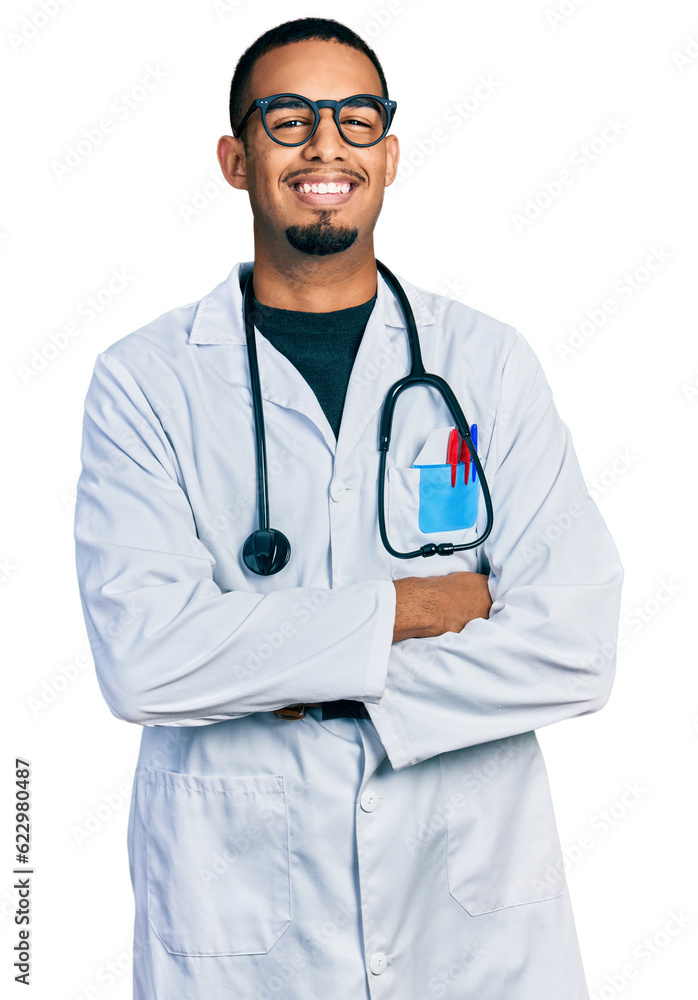 Young african american man wearing doctor uniform and stethoscope happy face smiling with crossed arms looking at the camera. positive person. Young african american man wearing doctor uniform and stethoscope happy face smiling with crossed arms looking at the camera. positive person.
