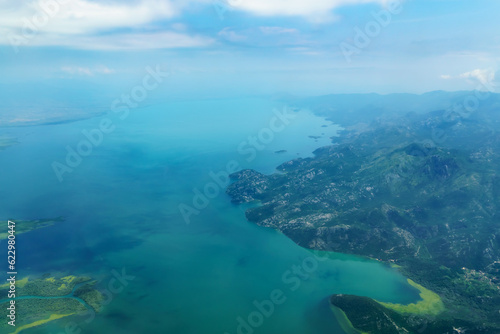 beautiful view of the coast of Montenegro from the height of an airplane flight  mountains and sea  blue sky with soft clouds  the concept of travel