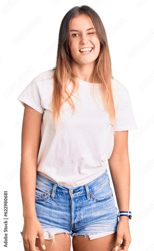 Fototapeta premium Beautiful caucasian woman wearing casual white tshirt winking looking at the camera with sexy expression, cheerful and happy face.