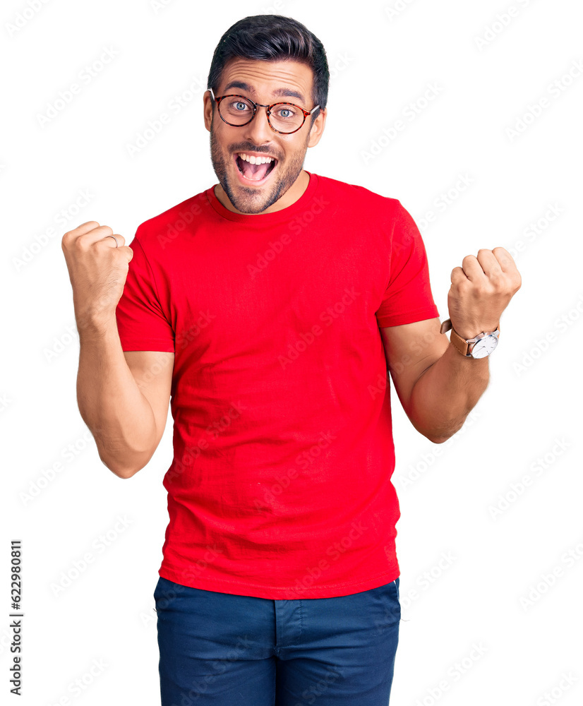 Young hispanic man wearing casual clothes and glasses screaming proud, celebrating victory and success very excited with raised arms Young hispanic man wearing casual clothes and glasses screaming proud, celebrating victory and success very excited with raised arms