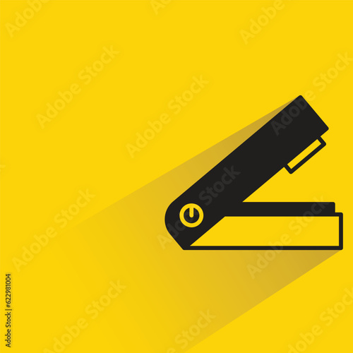 stapler with shadow on yellow background
