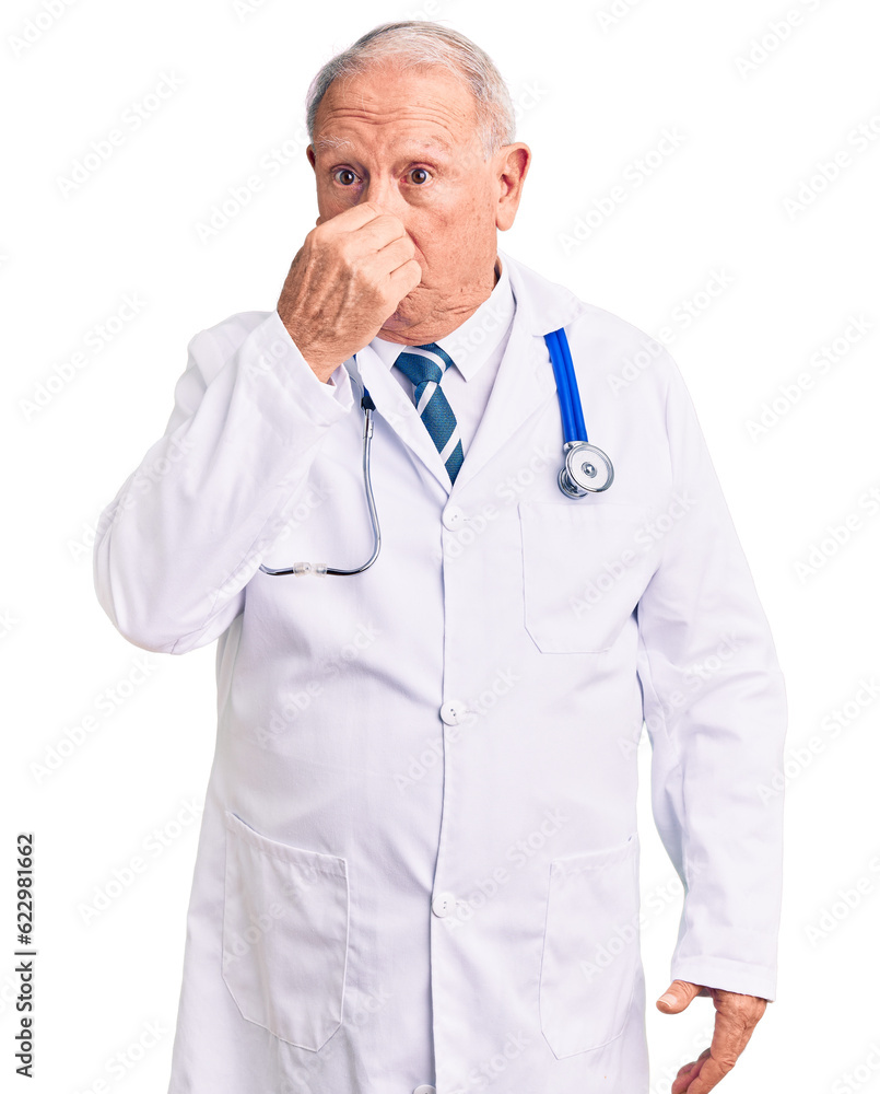 Senior handsome grey-haired man wearing doctor coat and stethoscope smelling something stinky and disgusting, intolerable smell, holding breath with fingers on nose. bad smell Senior handsome grey-haired man wearing doctor coat and stethoscope smelling something stinky and disgusting, intolerable smell, holding breath with fingers on nose. bad smell