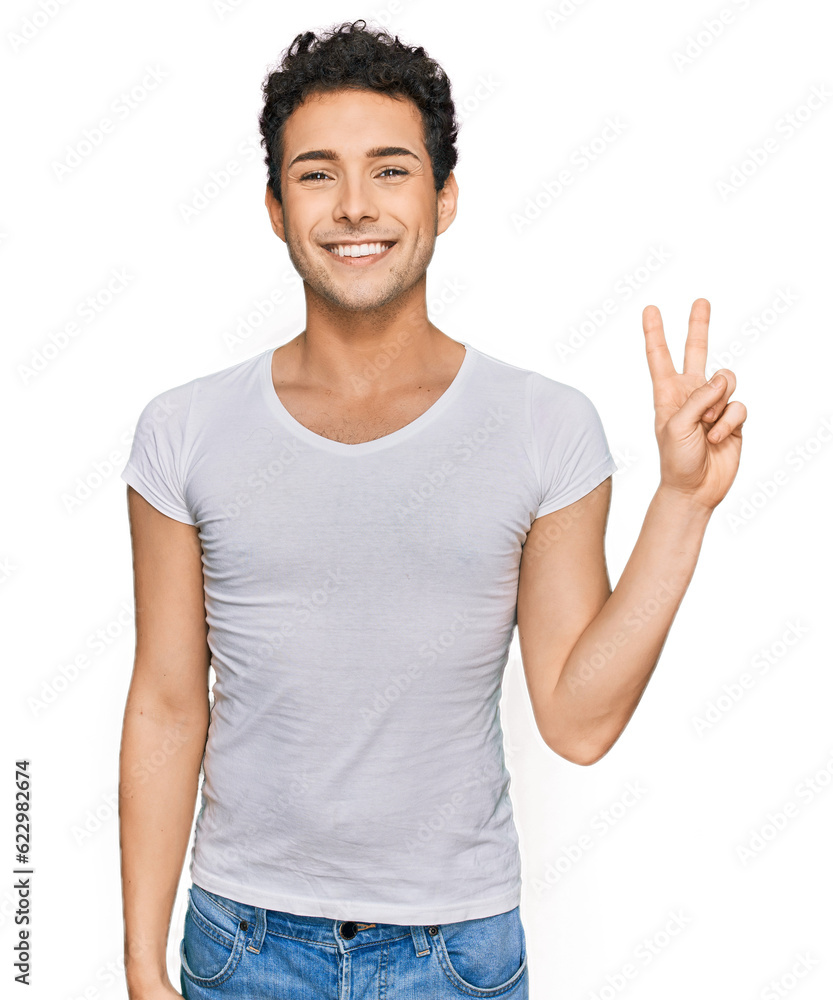Young handsome man wearing casual white t shirt smiling with happy face winking at the camera doing victory sign. number two. Young handsome man wearing casual white t shirt smiling with happy face winking at the camera doing victory sign. number two.
