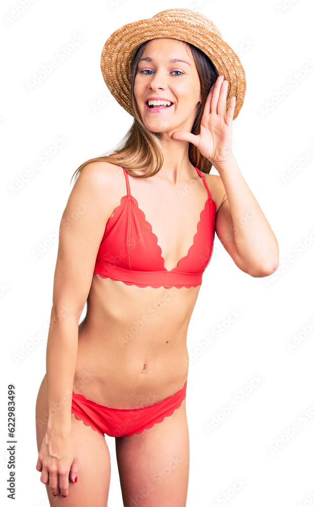 Beautiful brunette young woman wearing bikini smiling with hand over ear listening an hearing to rumor or gossip. deafness concept. Beautiful brunette young woman wearing bikini smiling with hand over ear listening an hearing to rumor or gossip. deafness concept.