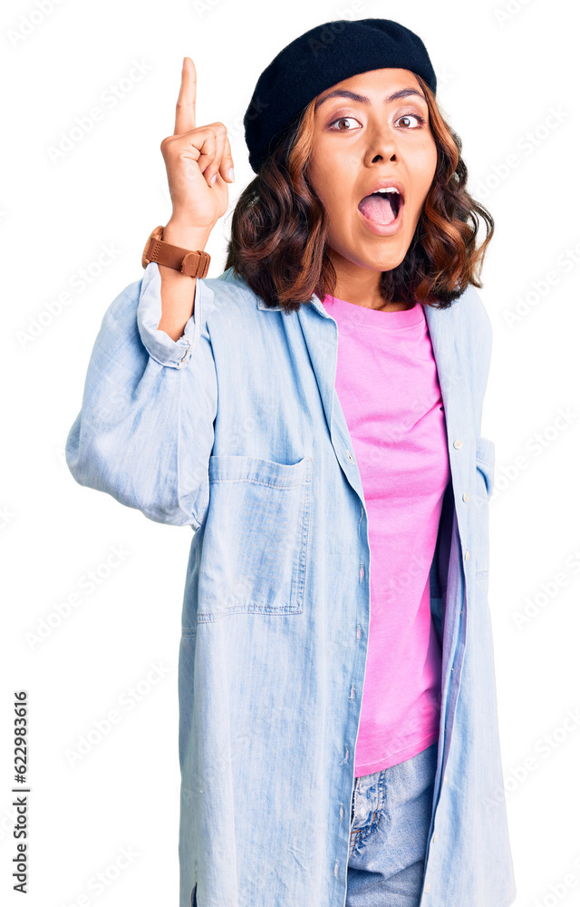 Young beautiful mixed race woman wearing french look with beret pointing finger up with successful idea. exited and happy. number one. Young beautiful mixed race woman wearing french look with beret pointing finger up with successful idea. exited and happy. number one.
