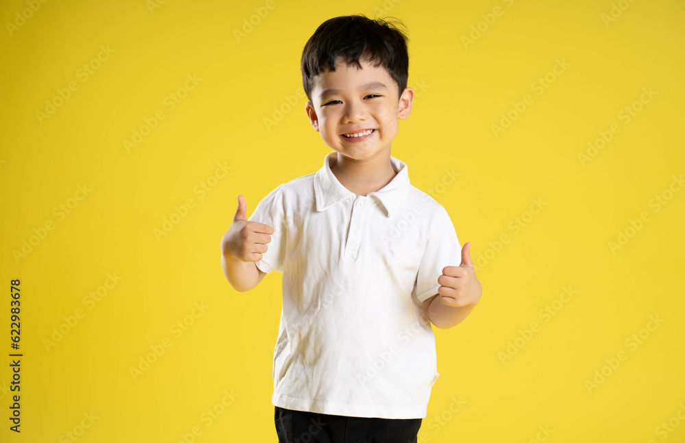 image of asian boy posing on a yellow background. image of asian boy posing on a yellow background.