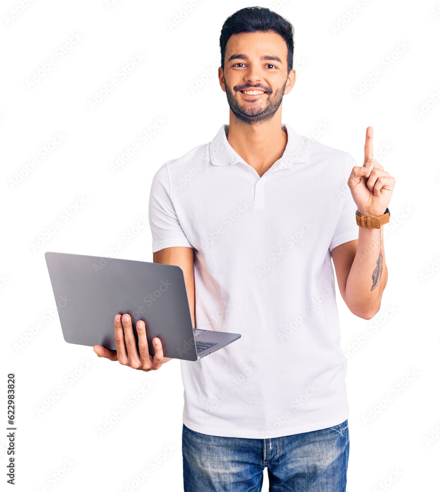 Young handsome hispanic man working using computer laptop surprised with an idea or question pointing finger with happy face, number one Young handsome hispanic man working using computer laptop surprised with an idea or question pointing finger with happy face, number one
