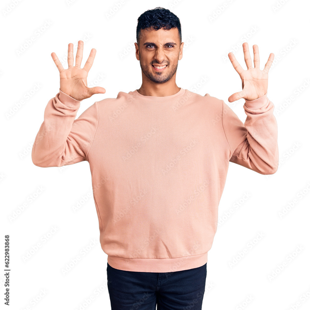 Young hispanic man wearing casual clothes showing and pointing up with fingers number ten while smiling confident and happy. Young hispanic man wearing casual clothes showing and pointing up with fingers number ten while smiling confident and happy.