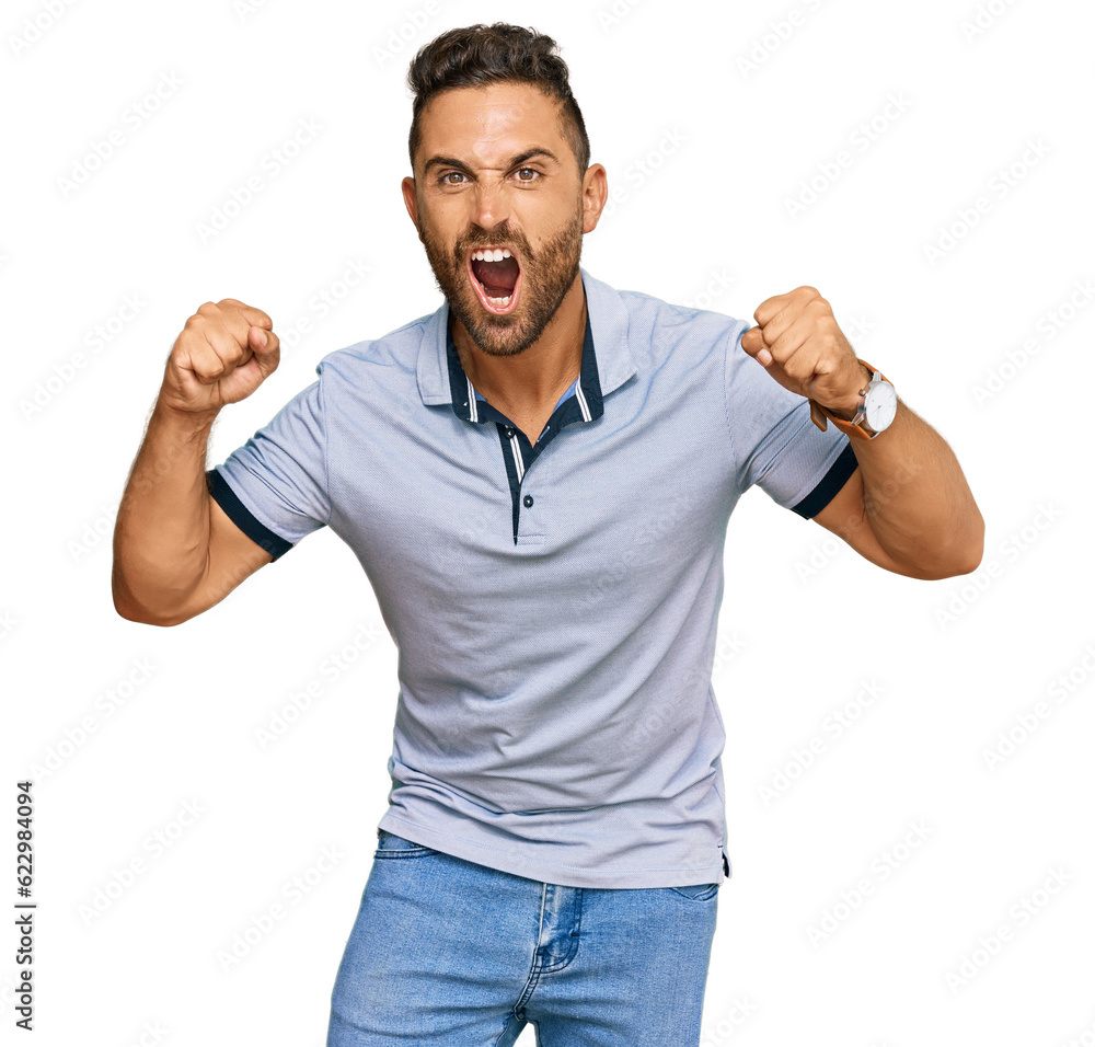 Fototapeta premium Handsome man with beard wearing casual clothes angry and mad raising fists frustrated and furious while shouting with anger. rage and aggressive concept.