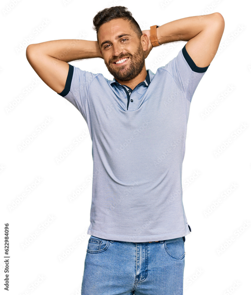 Handsome man with beard wearing casual clothes relaxing and stretching, arms and hands behind head and neck smiling happy Handsome man with beard wearing casual clothes relaxing and stretching, arms and hands behind head and neck smiling happy