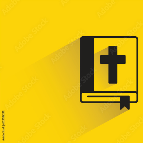 bible book with shadow on yellow background
